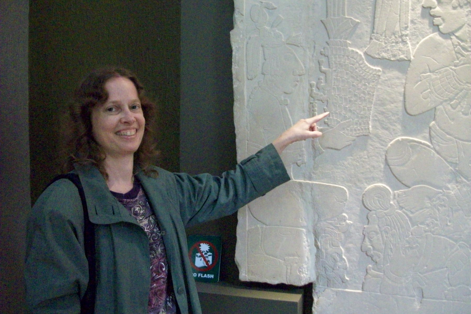Dr.Gaby Vail pointing out a detail in the Mayan stela in Palenque.